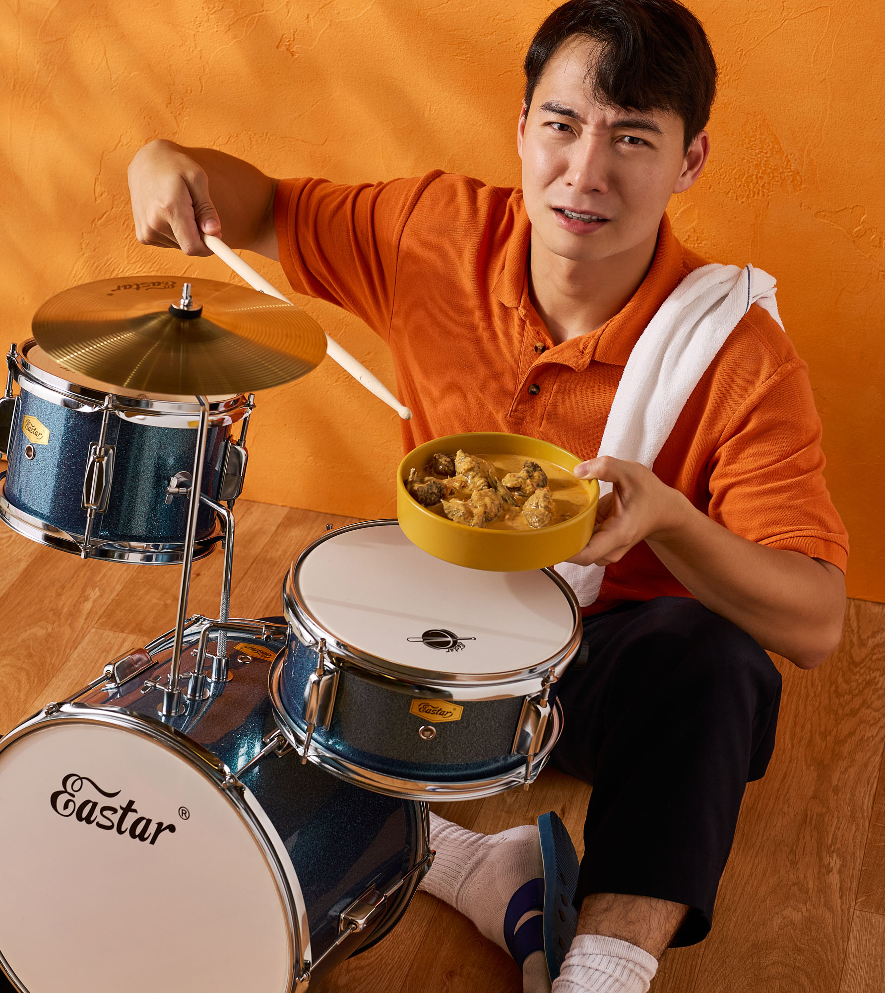 Nigel Ng eating from a bowl resting on a snare drum